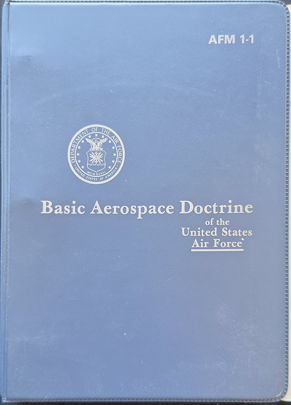 Dark blue binder printed AFM 1-1, Basic Aerospace Doctrine of the United States Air Force, with the Department of the Air Force seal
