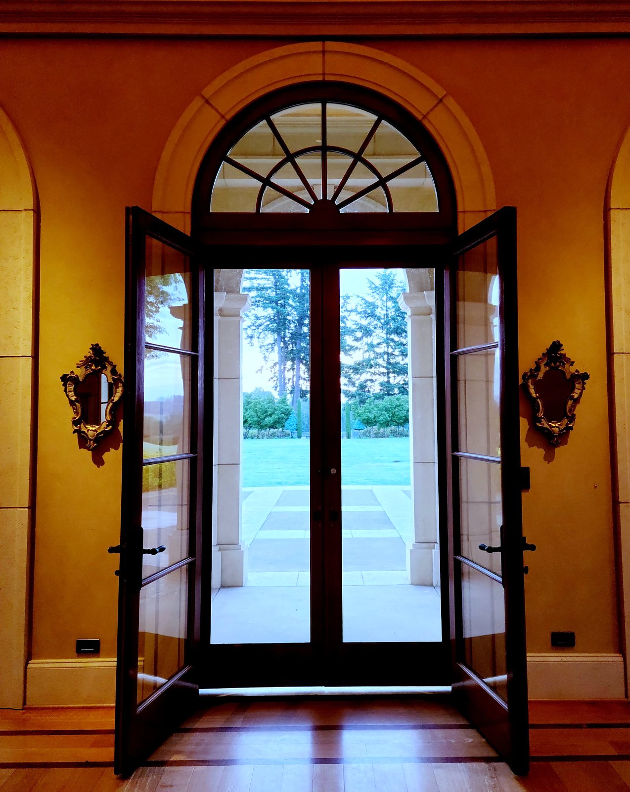 Arched glass doors opening to the grounds